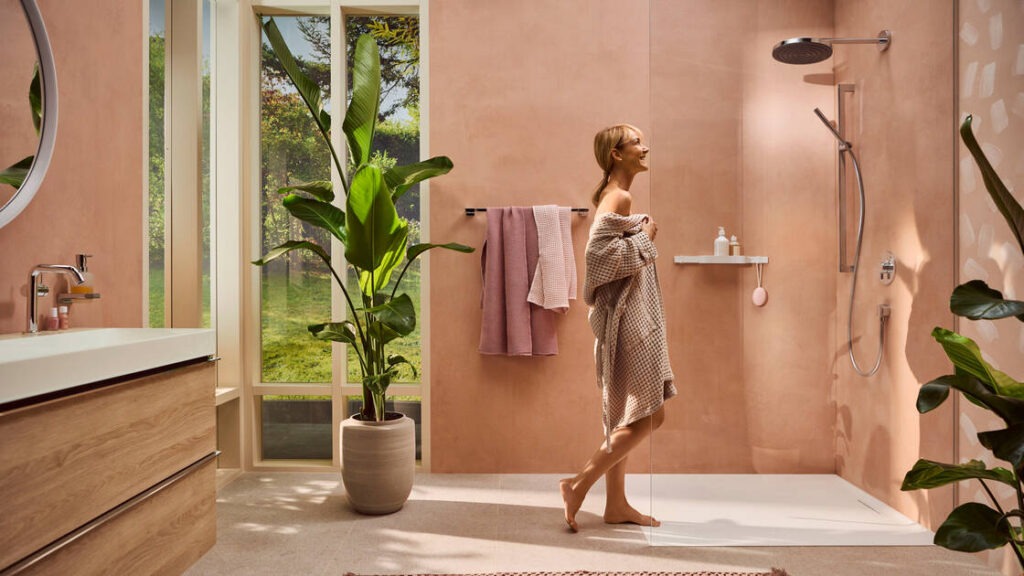 Femme qui s'apprête à prendre sa douche dans une salle de bains Hansgrohe équipée d'une douche à tête Pulsify S