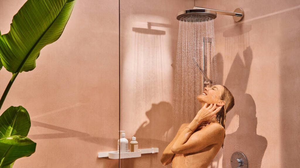 Femme qui prend sa douche dans une salle de bains Hansgrohe équipée d'une douche à tête Pulsify S